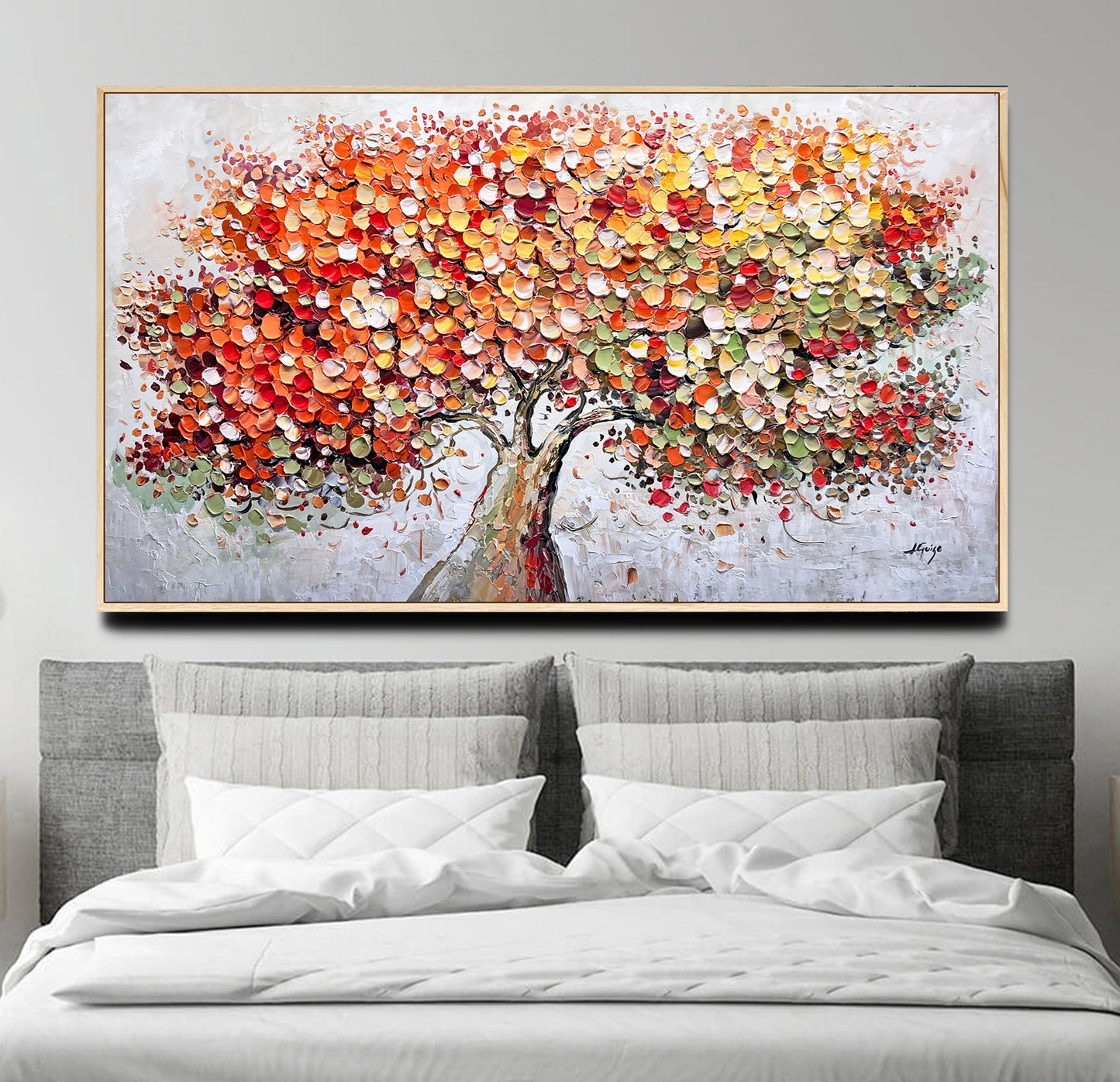 a painting of a tree on a wall above a bed