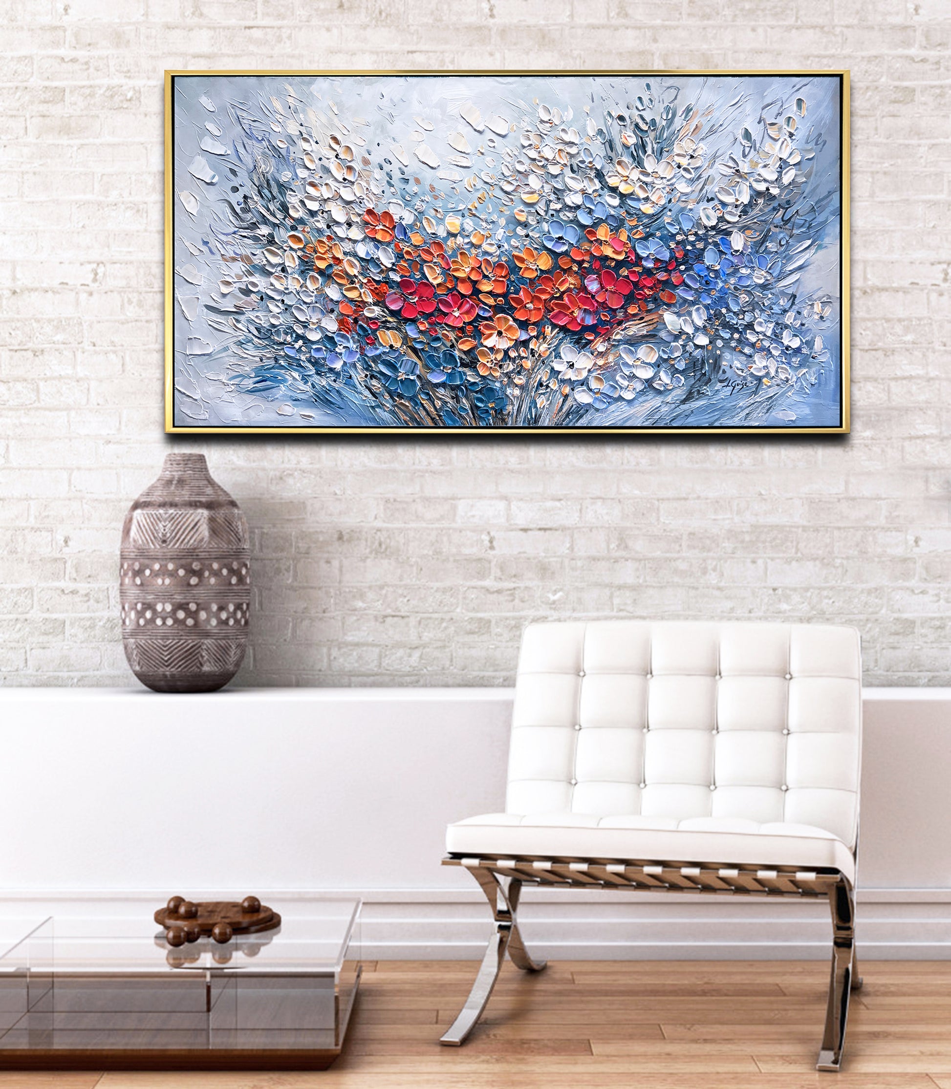 a white chair sitting in front of a painting on a wall