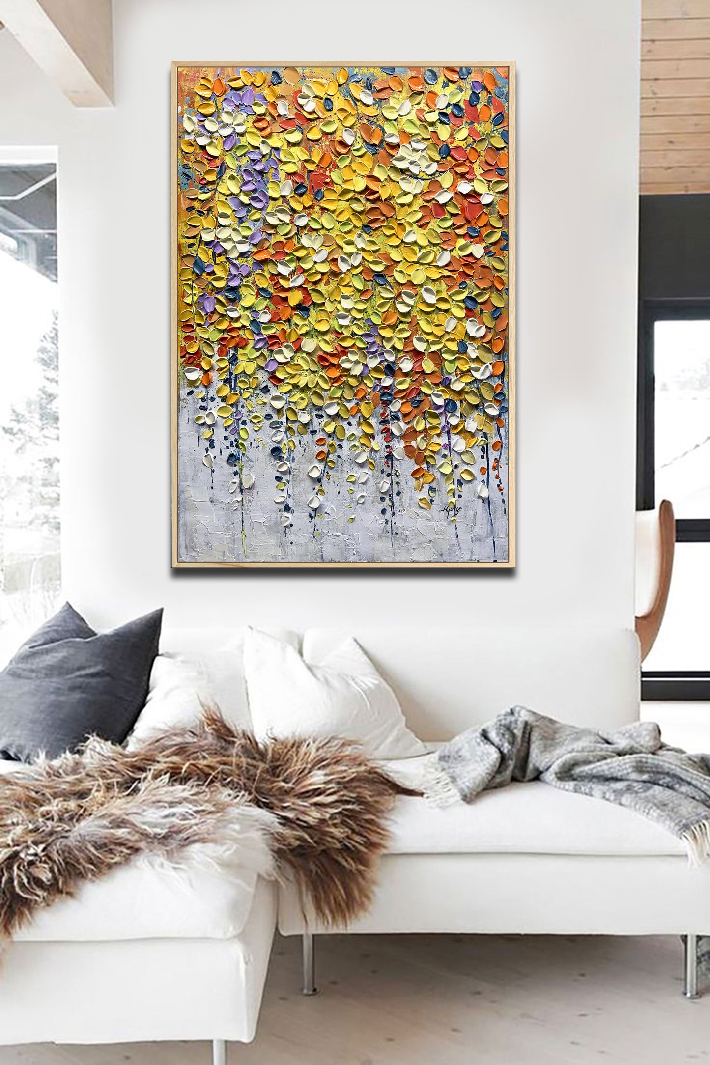 a living room with a white couch and a painting on the wall