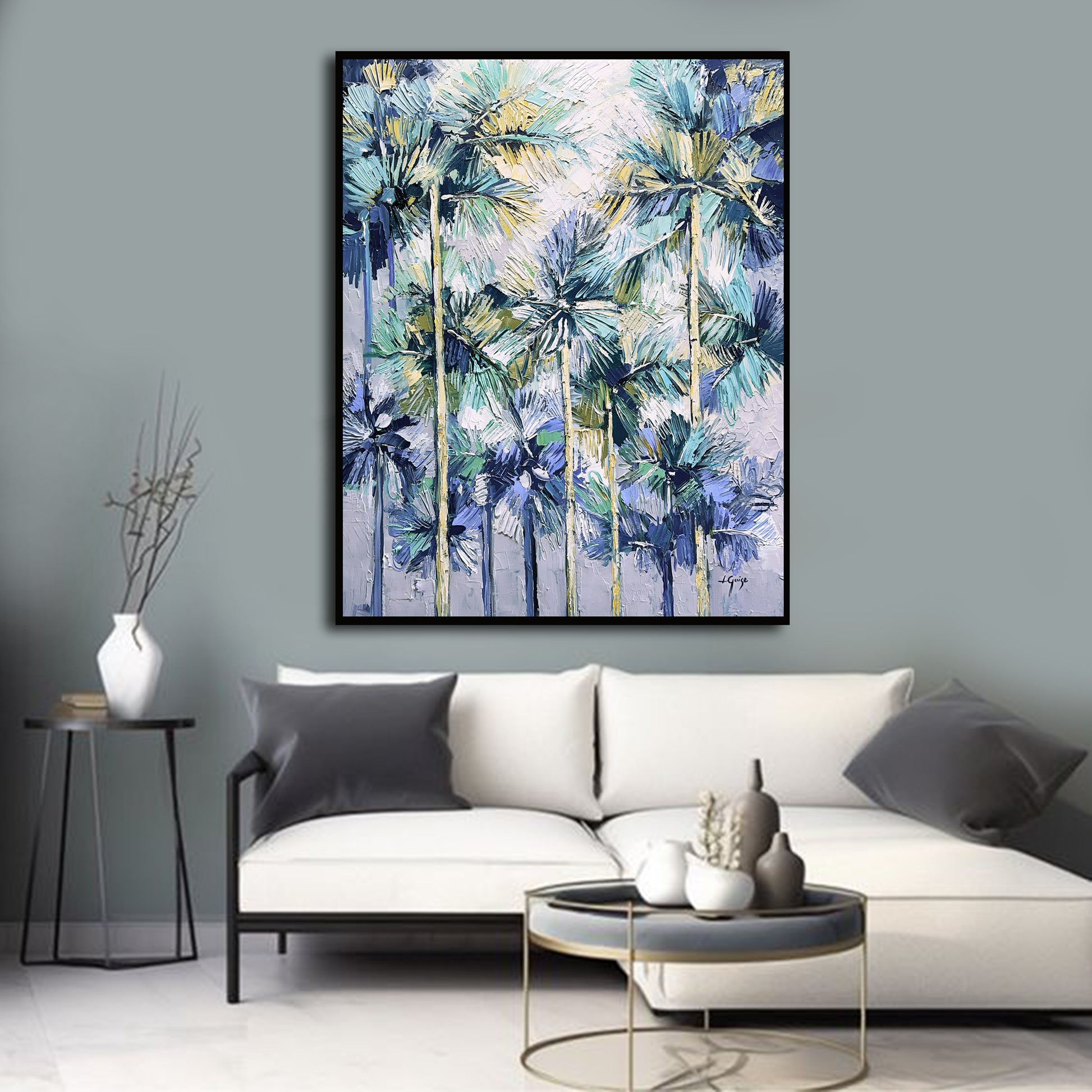 a living room with a white couch and a painting on the wall