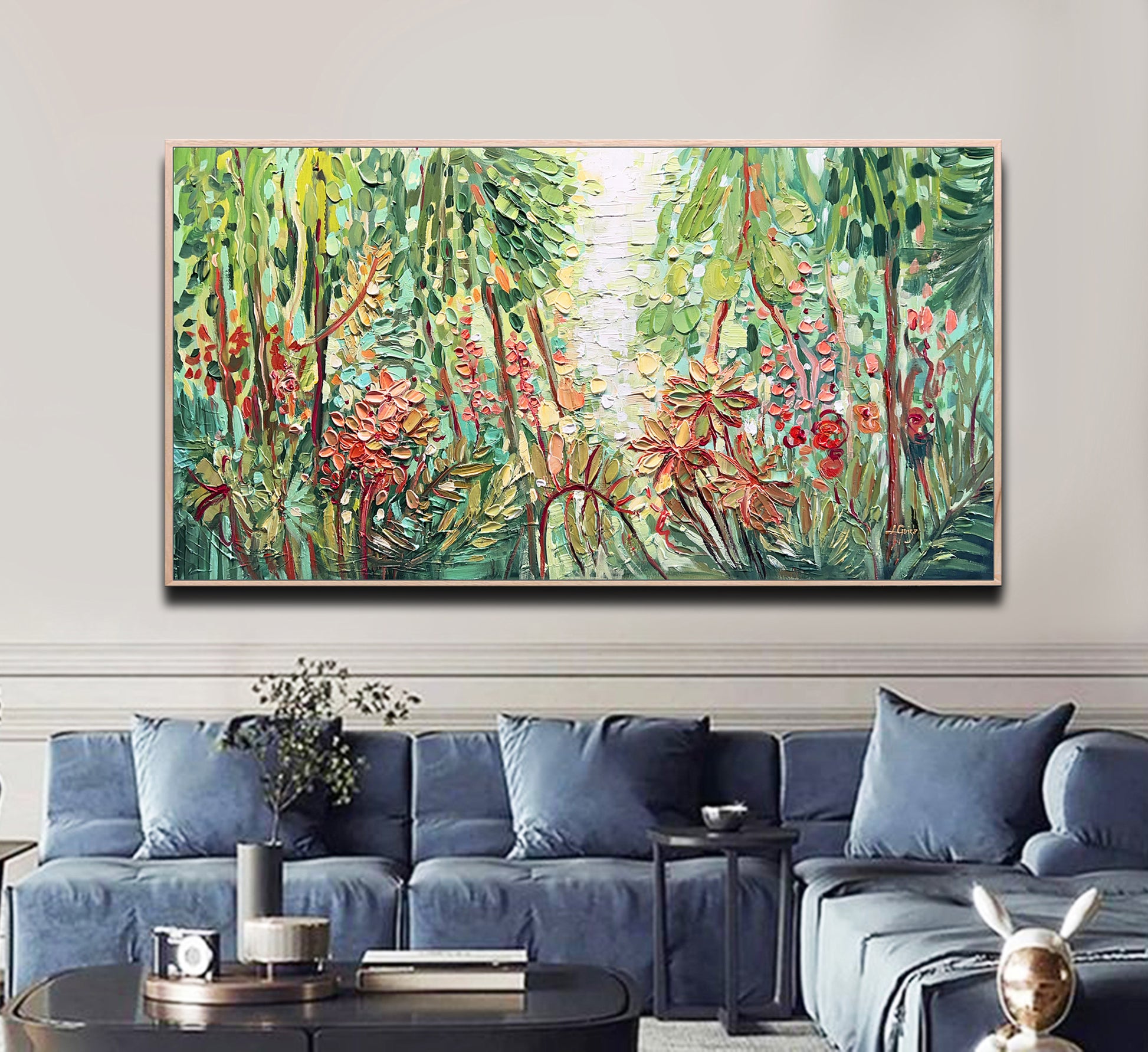 a living room with a blue couch and a painting on the wall