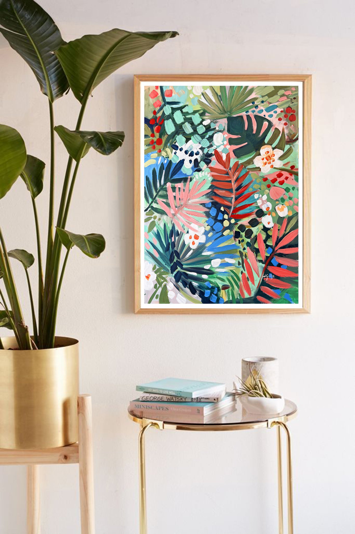 a plant in a pot next to a painting on a wall