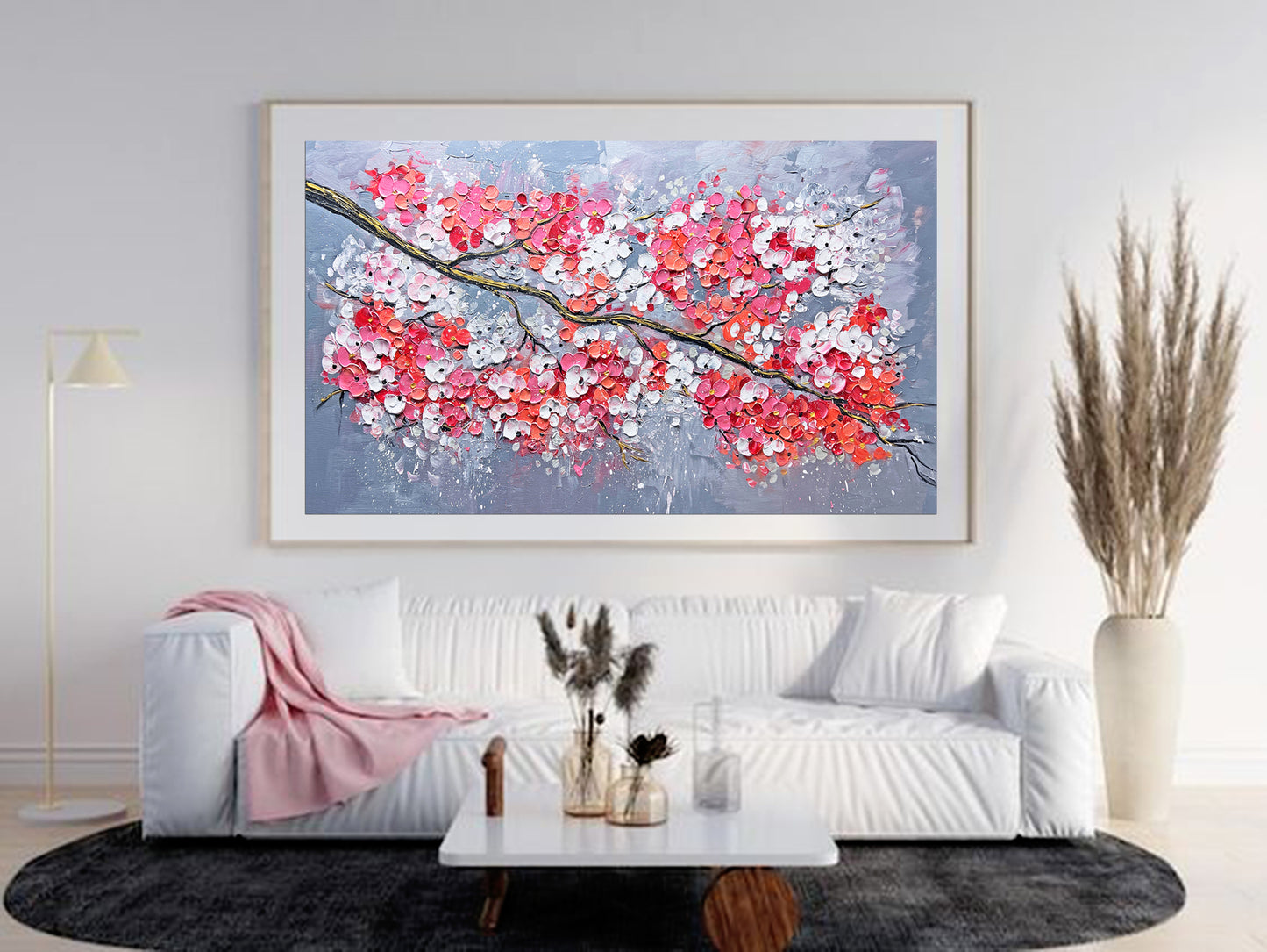a living room with a white couch and a painting on the wall