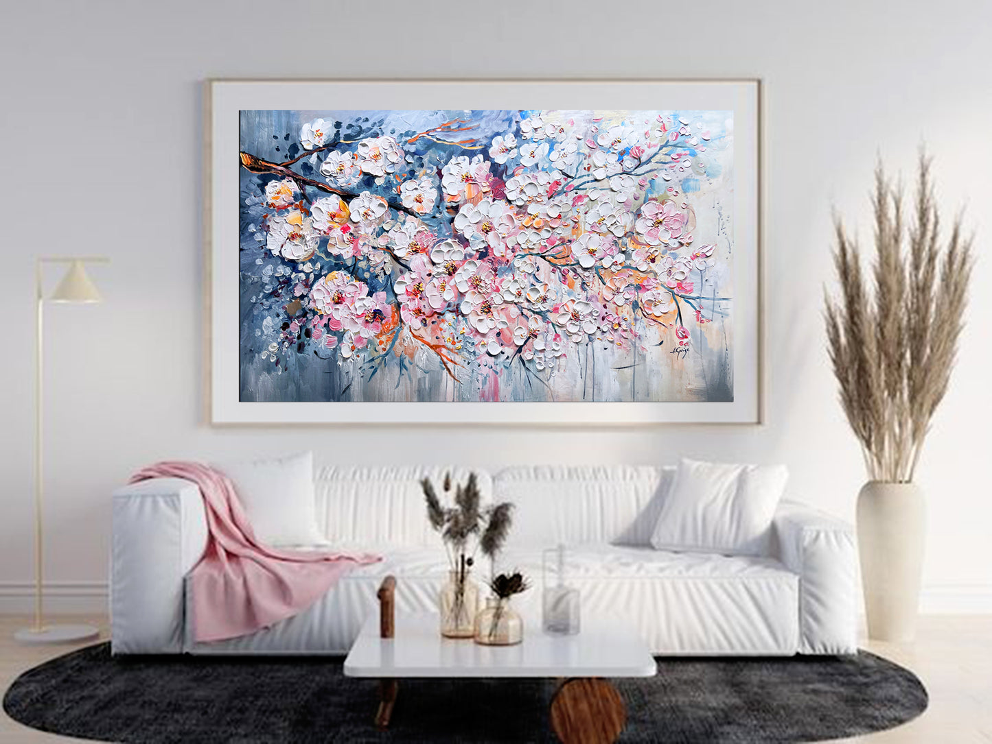 a living room with a white couch and a painting on the wall