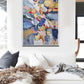 a living room with a white couch and a painting on the wall