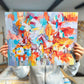 a person holding up a piece of art