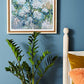 a bedroom with blue walls and a painting on the wall